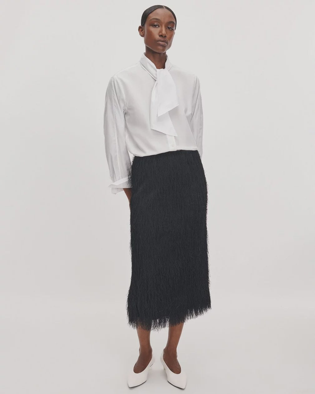 Rag &amp; Bone Amalia black fringe column skirt and white tie-neck blouse.