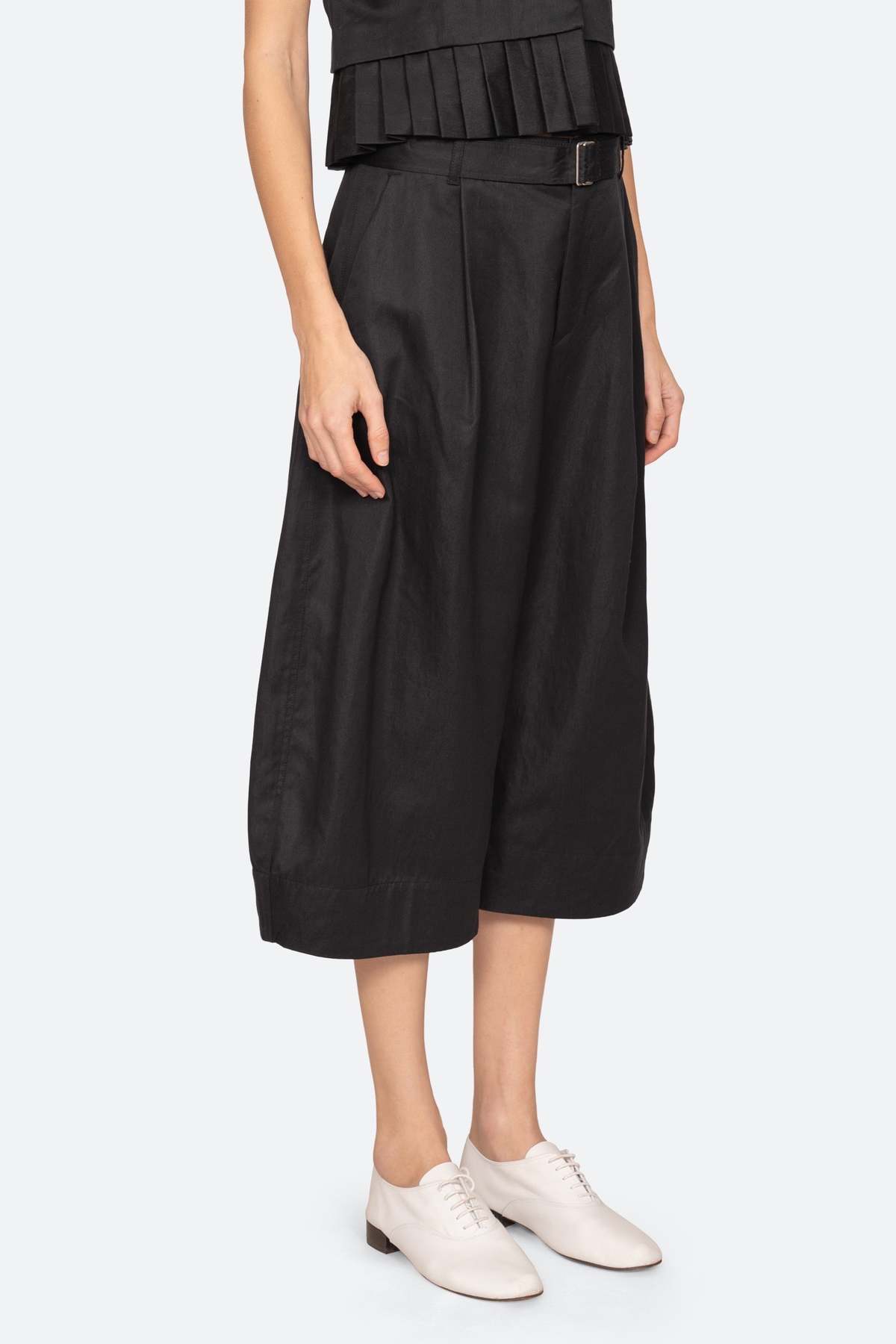 A person wearing the Sea New York Angelina Suiting Culotte paired with white oxford shoes and a black sleeveless top. The outfit fits true to size. Image is cropped at the chest, showing only the lower half of the body.