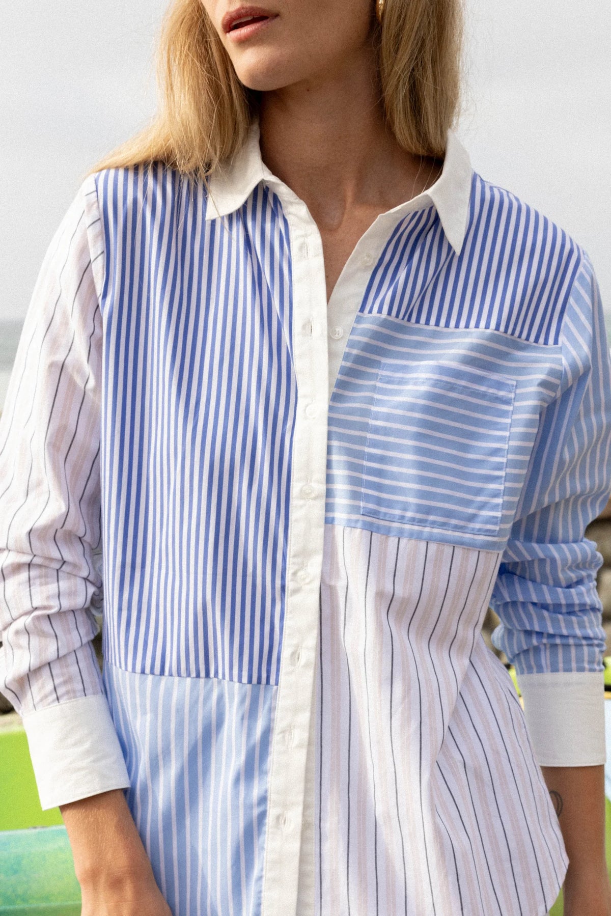 Woman wearing THE SHIRT’s Boyfriend Shirt in patchwork blue and white stripes, modern fit with No Gape detail.