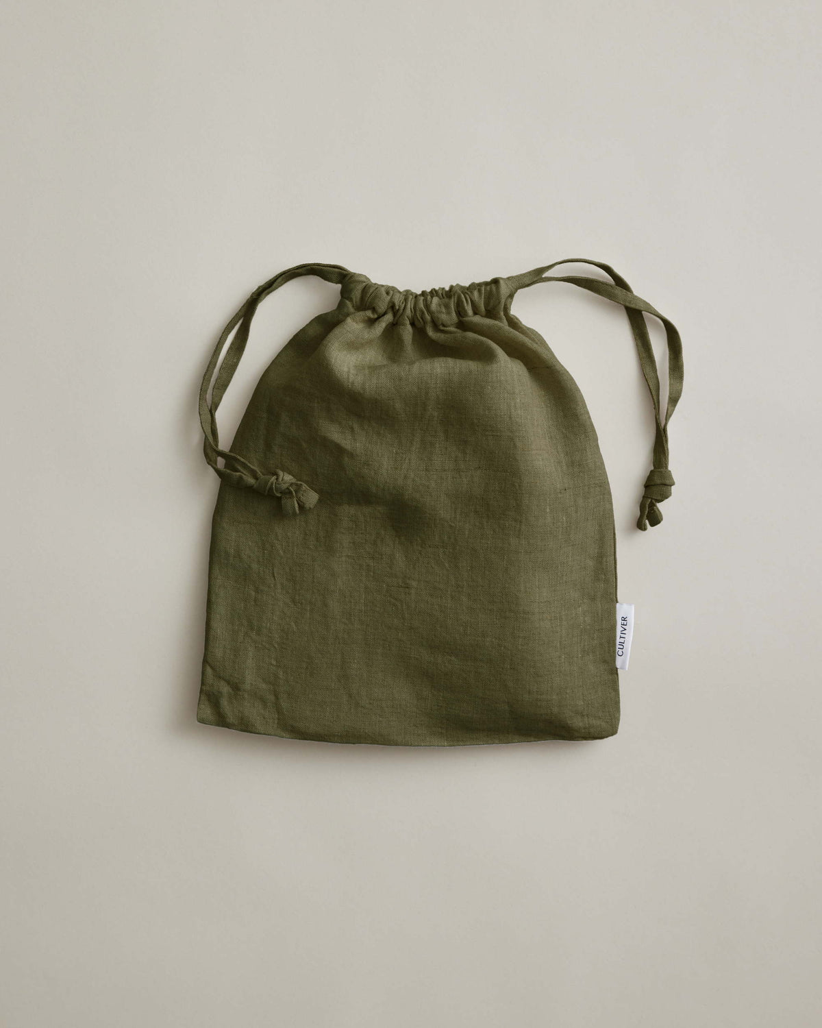 Olive green linen pillowcases by Cultiver Goods, set of 2, displayed on a light beige background.