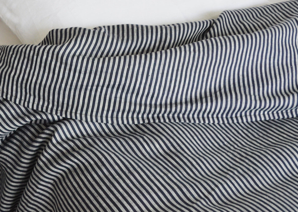 Rumpled Baltic Queen Duvet by Plum Textiles in soft white on bed with matching pillow, cozy bedroom style.