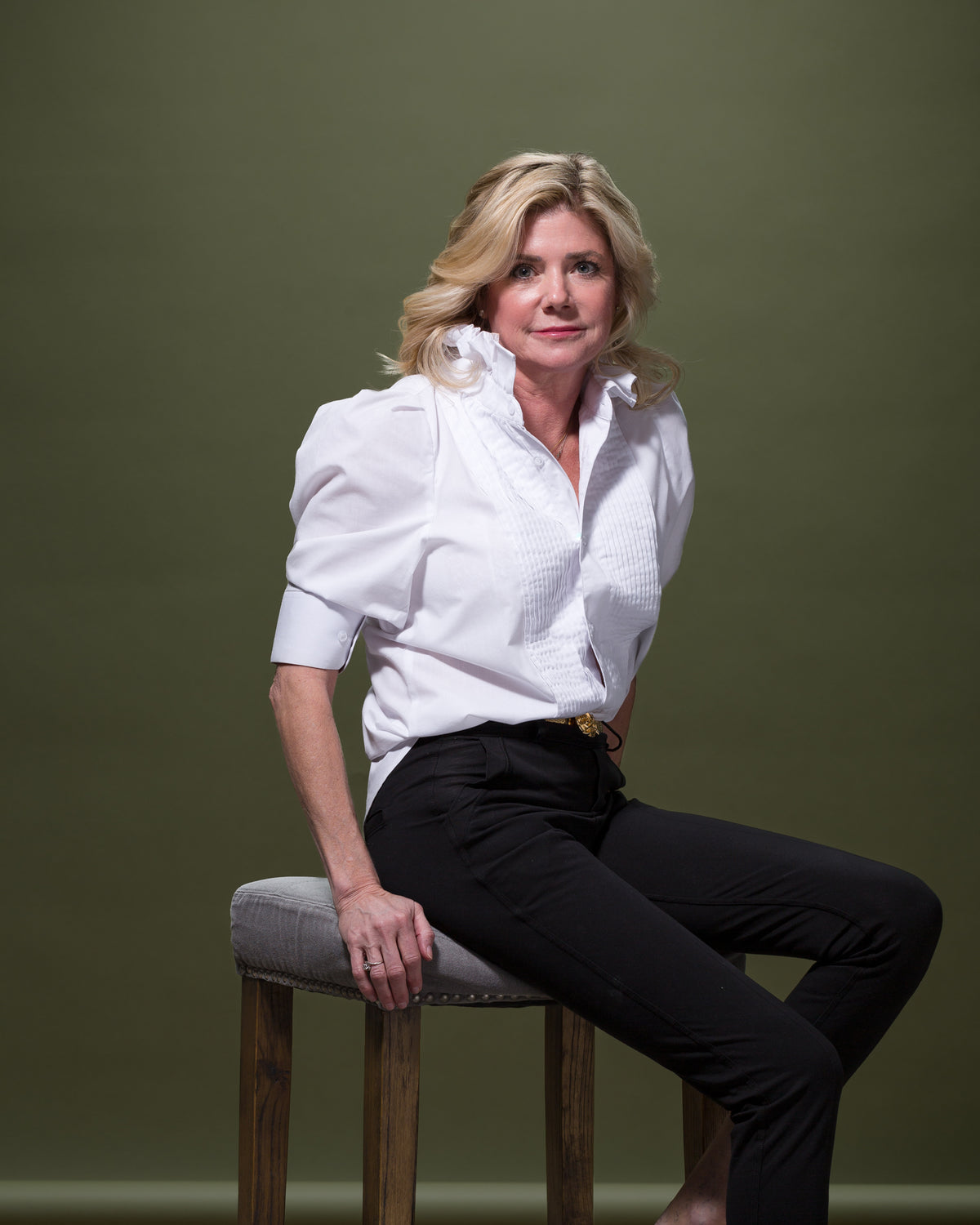 Modern white blouse and black pants styled on a model, Bungalow Furniture & Accessories, minimalist green backdrop.
