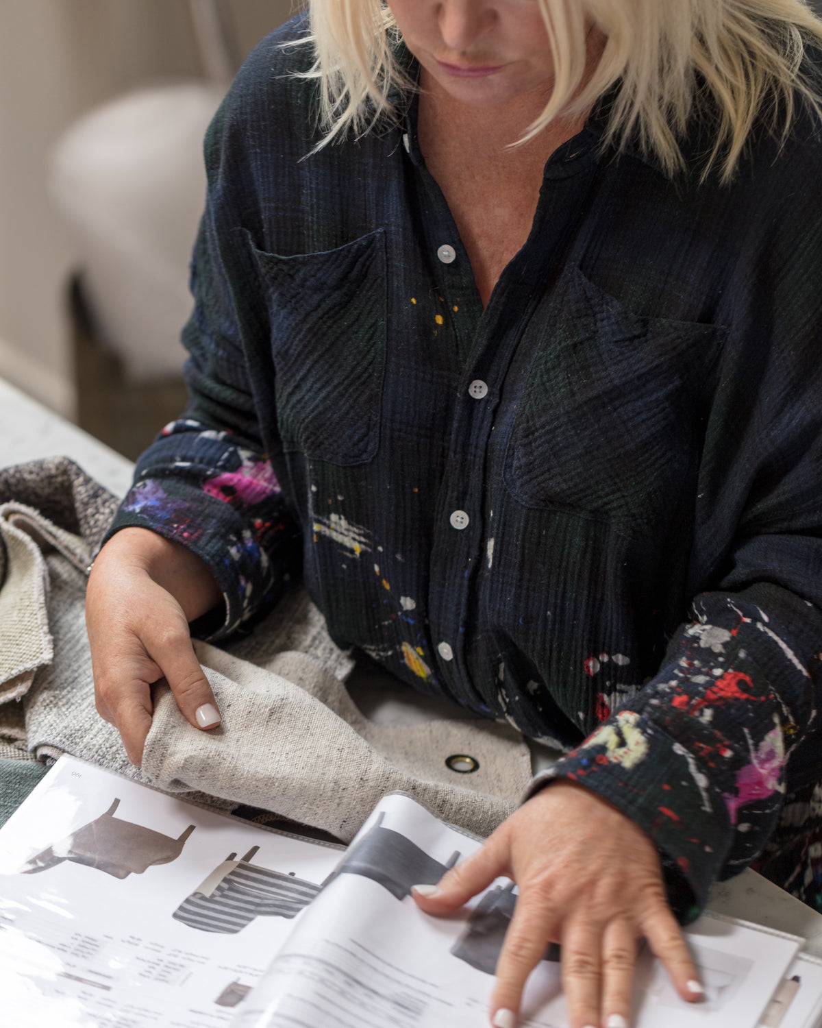 Designer selecting fabric swatches next to modern furniture styles at Bungalow Furniture & Accessories showroom.