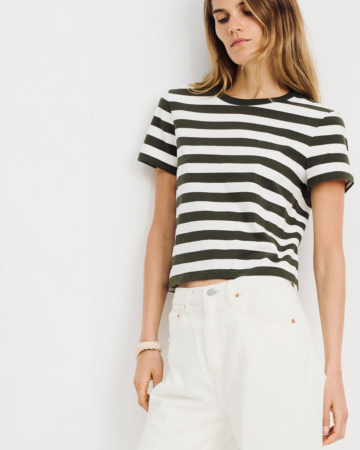 Black-and-white striped t-shirt with white jeans, styled in a modern, minimalist look for Bungalow Furniture & Accessories.