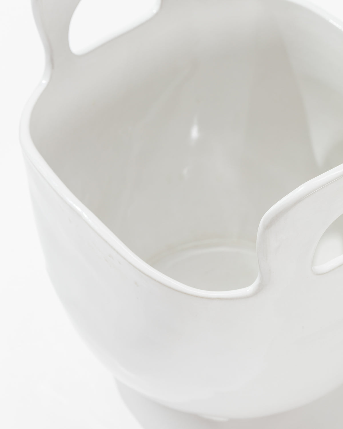 Close-up image of Montes Doggett's 4994 Bowl no. 994, a high-fired ceramic container with a smooth, glossy finish. This sculptural statement piece features two large, curved handles on opposite sides and a wide, open mouth. Handmade in Peru, the white background highlights the container's intricate details clearly.