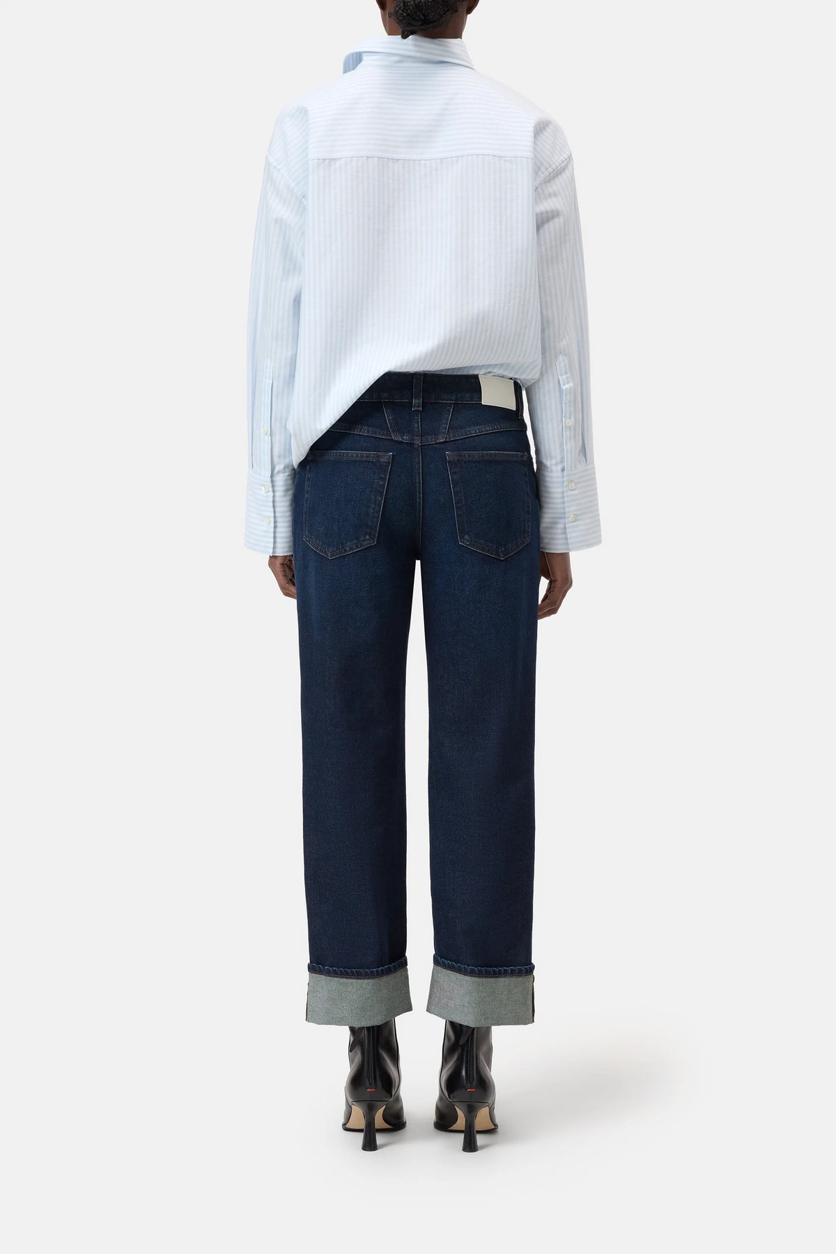 CLOSED Milo straight-leg sustainable denim jeans in blue, styled with a light shirt and heeled boots, back view.