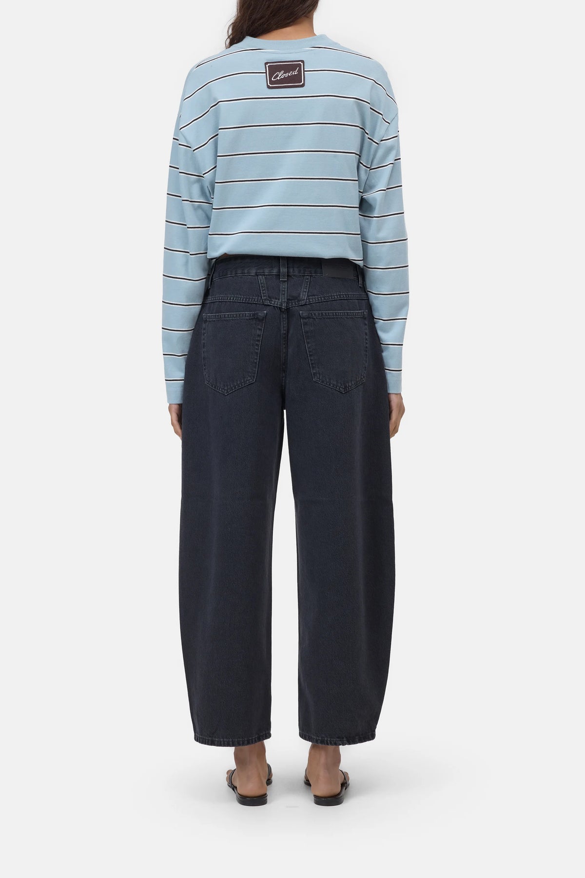 Light blue striped Jazzie shirt and barrel fit organic denim jeans by CLOSED, shown barefoot in a casual setting.