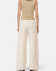 A person stands facing away, wearing CLOSED's Jayla Denim—high-waisted, wide-fit ecru jeans with raw hems and two back pockets, crafted in Italy. The plain white background highlights the beige sleeveless ribbed top.