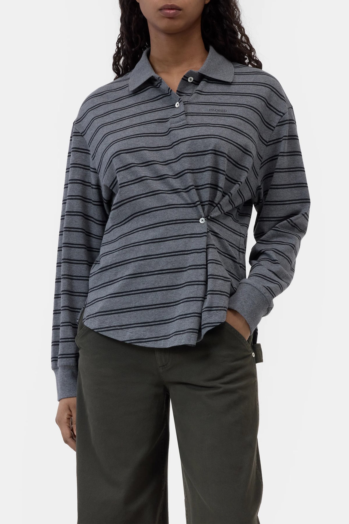 Gray striped CLOSED polo longsleeve with asymmetrical buttons, paired with olive pants, modern casual style.