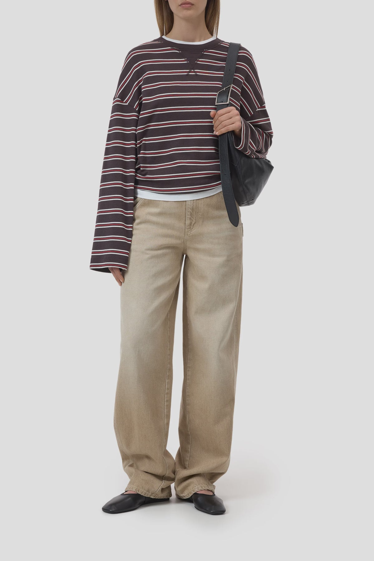 CLOSED crewneck longsleeve and baggy beige jeans styled with black shoes and a black shoulder bag.