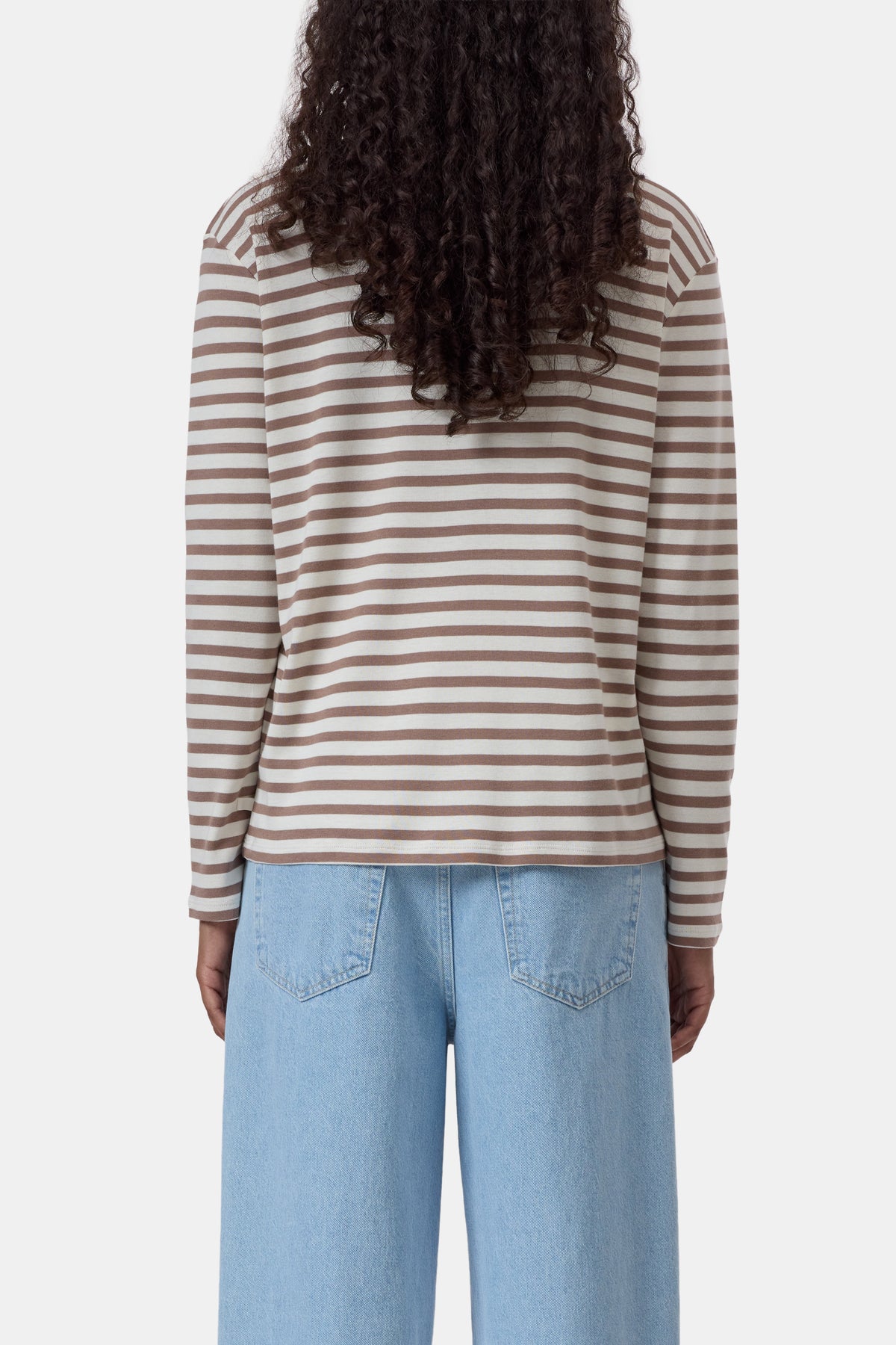 Beige and white ribbed jersey long sleeve tee by CLOSED, shown from the back, paired with light blue jeans.