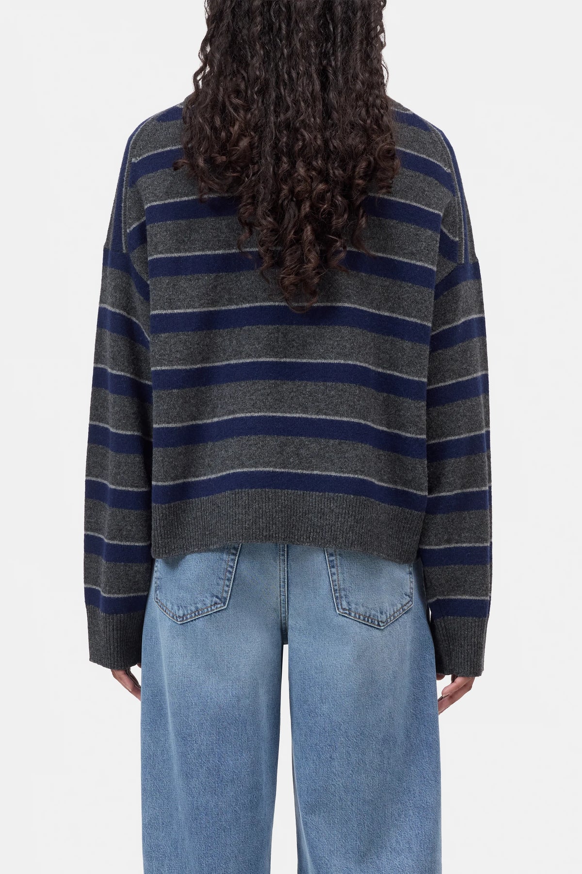 CLOSED striped crew neck sweater in blue, shown from the back with casual styling and visible curly hair.
