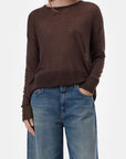 CLOSED crew neck long sleeve top in ivory with blue jeans, model standing against a white background.
