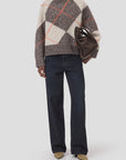 CLOSED ArgyleR longsleeve in argyle pattern, styled with dark jeans and tan shoes, holding brown clutch.