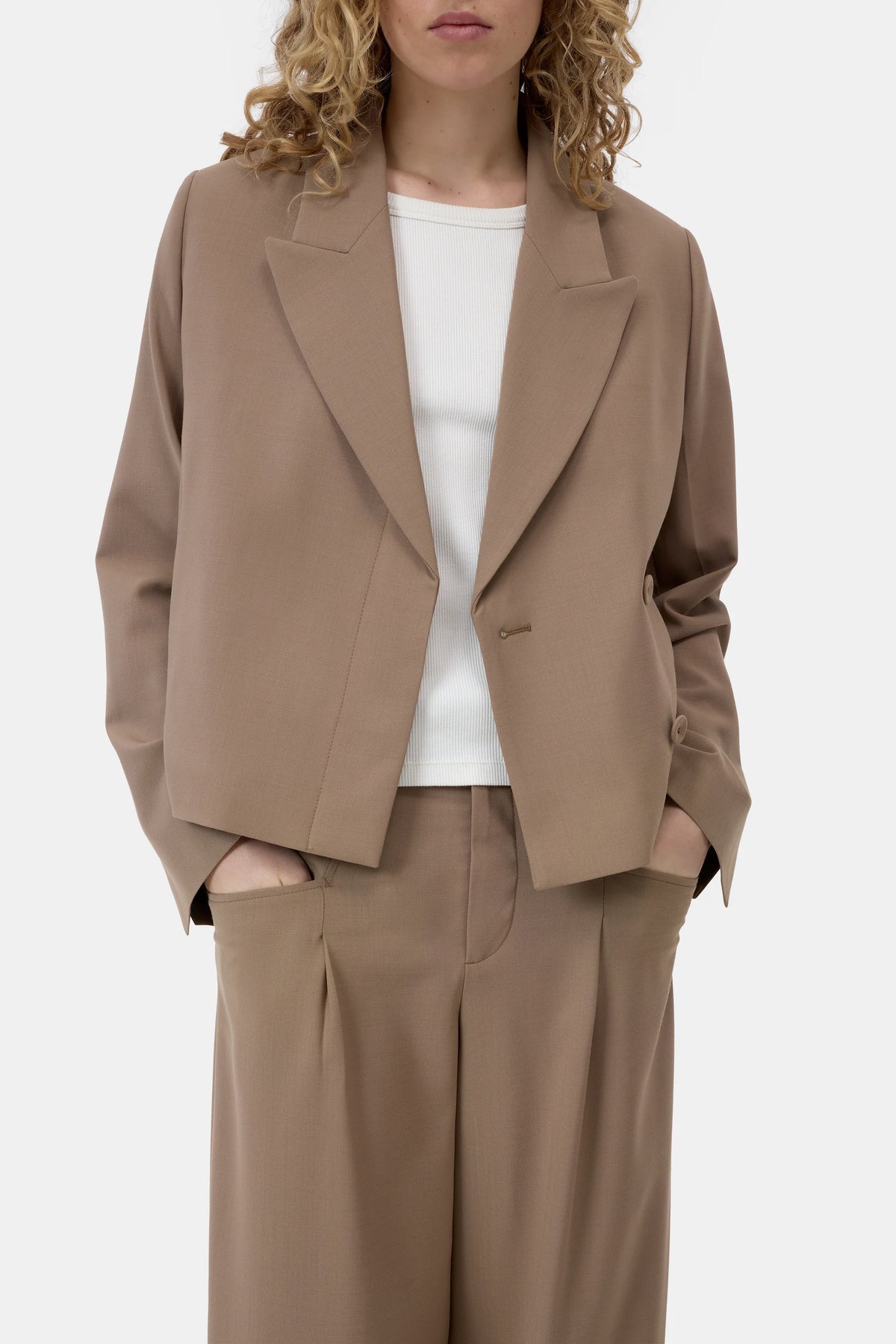 CLOSED cropped blazer in black over white top, model with hands in pockets, minimal studio background.
