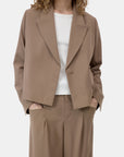 CLOSED cropped blazer in black over white top, model with hands in pockets, minimal studio background.