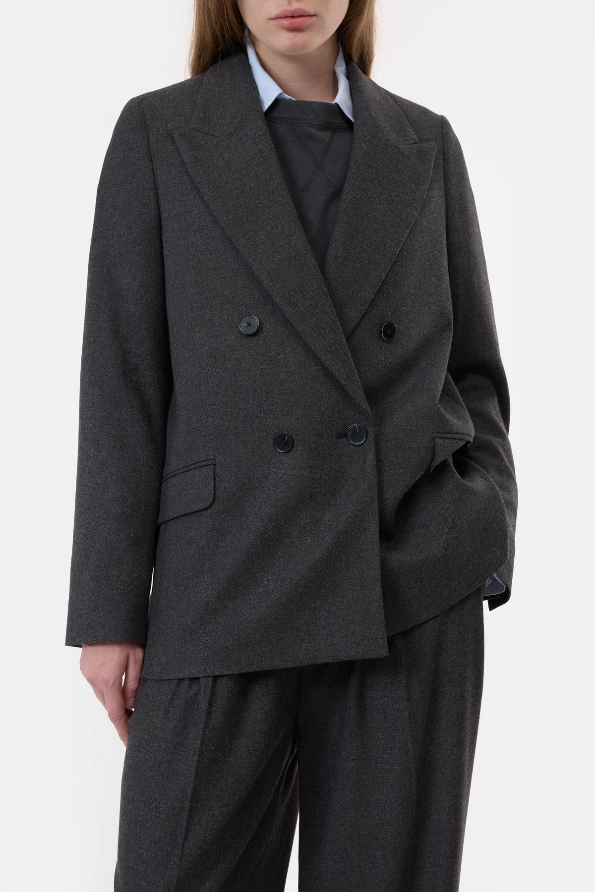 A person models the CLOSED Fitted Doublebreasted Blazer in dark gray with matching trousers, styled over a black top and light blue collared shirt, standing against a plain white background with one hand in their pocket.