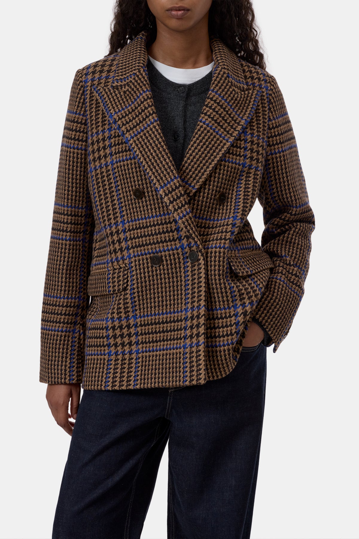 Sand beige fitted double-breasted blazer by CLOSED styled with black shirt, white tee, and dark jeans.