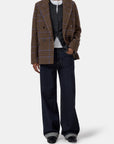 Closed fitted double-breasted blazer in gray, styled with dark jeans and black shoes; classic menswear look.