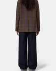 Fitted double-breasted blazer and wide-leg jeans, shown from back, model with long curly hair, Bungalow Furniture.