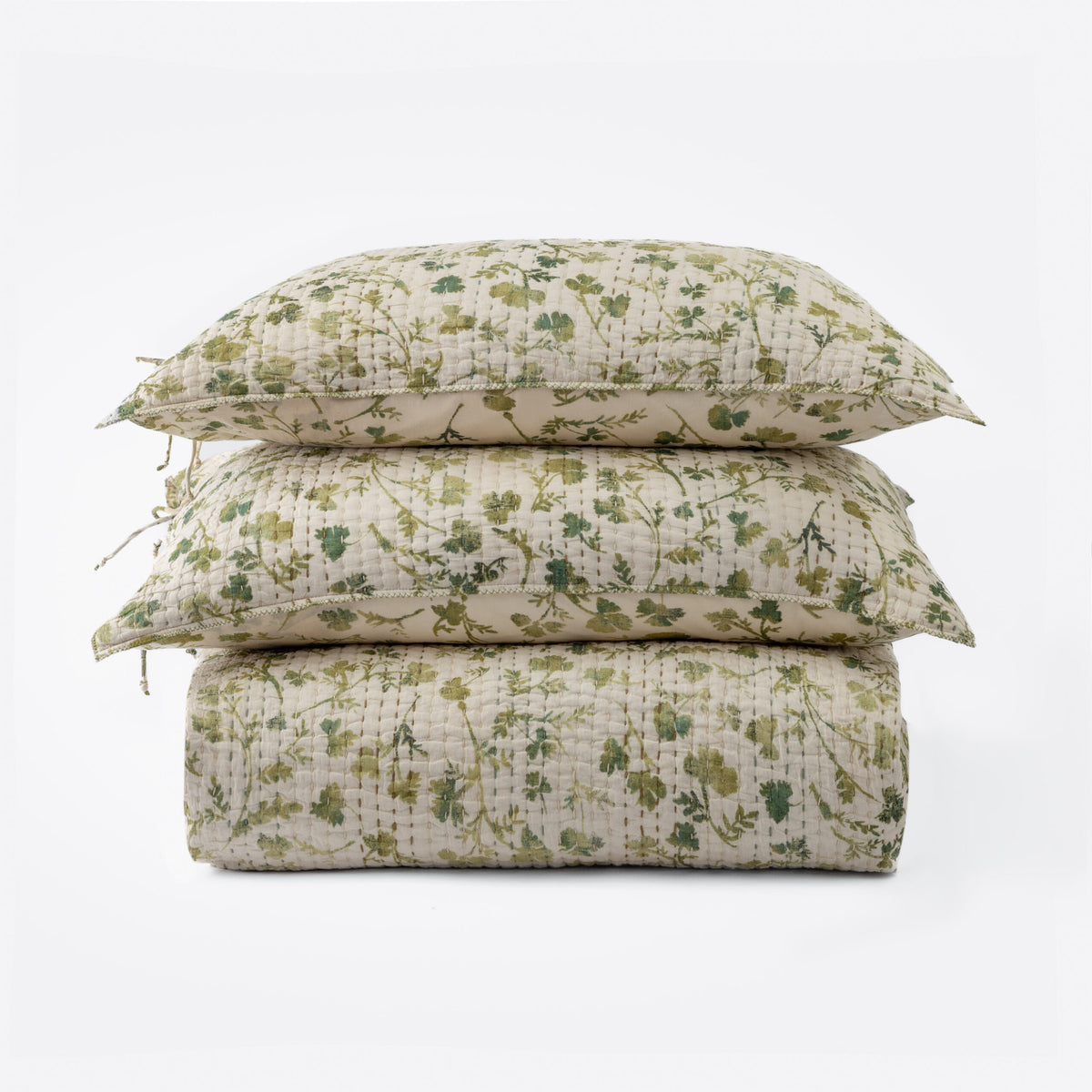 A neatly stacked set features two Millie Euro Shams and a quilt by Amity Home, all with a green and beige solar print floral pattern on soft cotton voile, arranged against a plain white background.