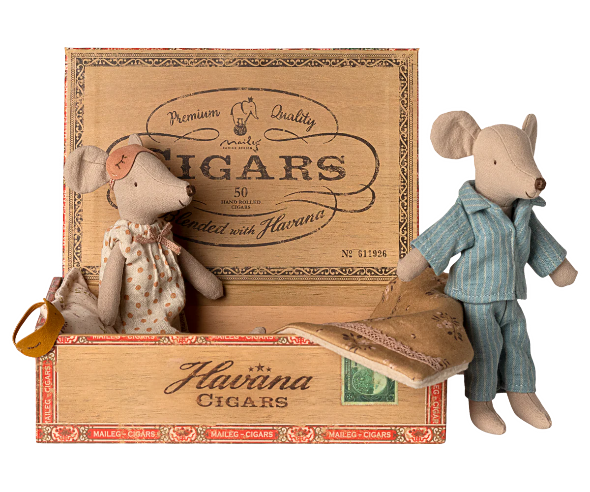 Maileg Mum & Dad Mice in a cigar box bed by Maileg, with Mum in a dress and Dad in striped pajamas, cozy under a blanket.