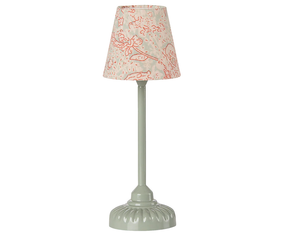 The Maileg Vintage Floor Lamp by Maileg features a pale green ridged base and stem, with a beige lampshade adorned in a pink floral pattern. Its soft glow and vintage design add charm, shown here against a plain white background.