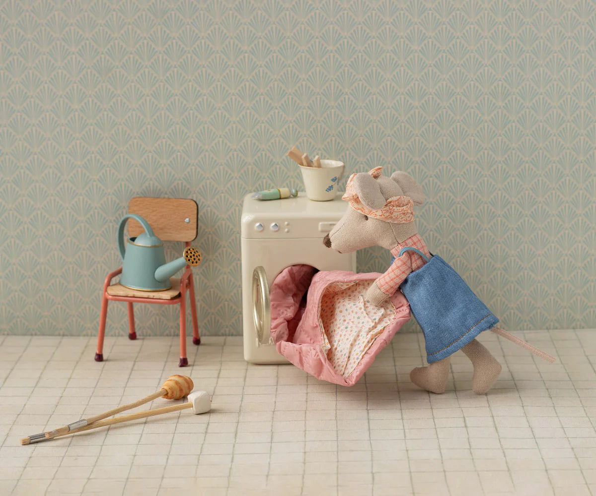 Maileg Hiker Mouse in blue dress loading a mini washer, with charming laundry accessories beside her.