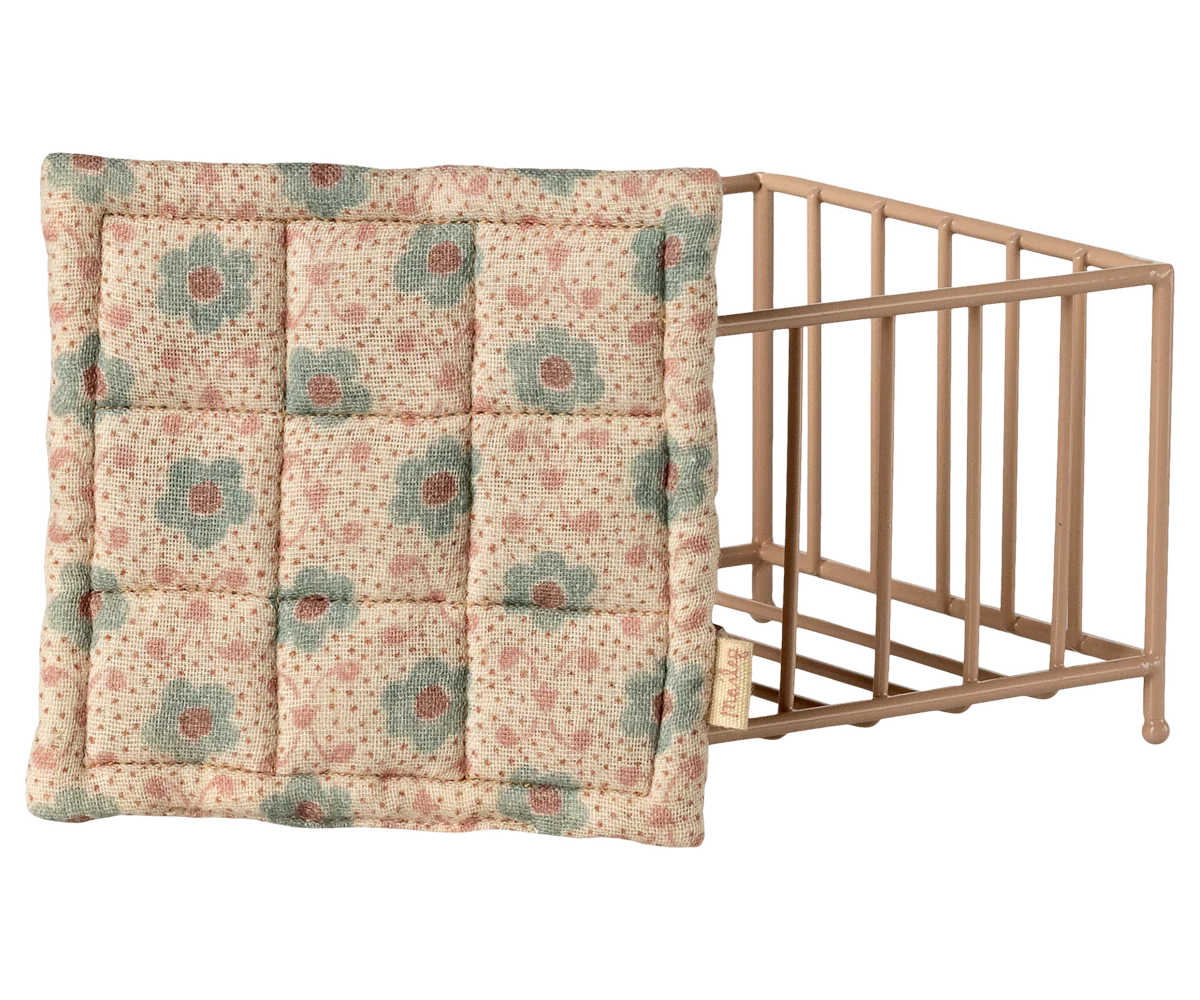 The Maileg Playpen by Maileg is a metal wire storage basket with a quilted, padded lid featuring delicate floral patterns in pastel pink and green, inspired by the charming Maileg playpen design.