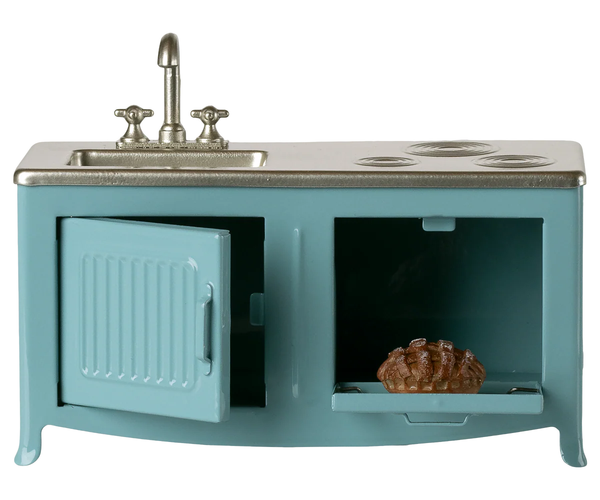 The Maileg Kitchen is a miniature blue metal playset with sink, stove, and oven. The oven door opens to reveal a small pie inside. Ideal for mouse houses or as a model, it’s perfect for imaginative play.