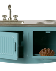 The Maileg Kitchen is a miniature blue metal playset with sink, stove, and oven. The oven door opens to reveal a small pie inside. Ideal for mouse houses or as a model, it’s perfect for imaginative play.