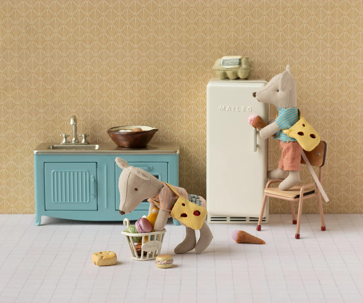 Maileg Little Brother Mouse with Bag in a playful kitchen scene, one cleaning, one at the fridge, food scattered.