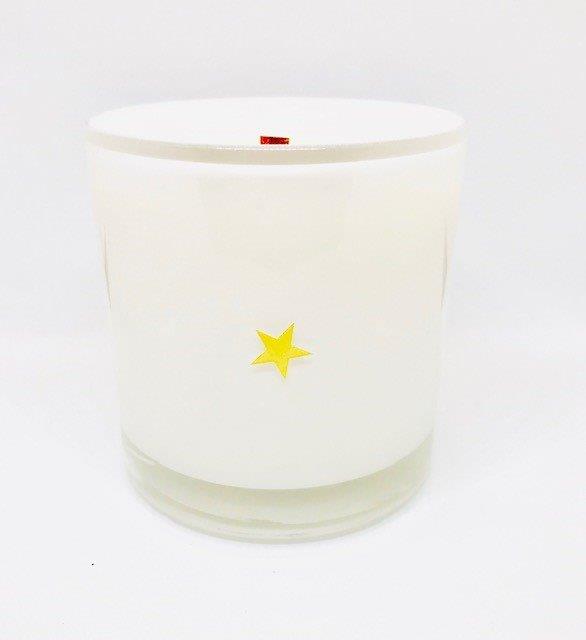 The Fritz & Troy Sweet & Salty Candle is made of white coconut/soy wax in a clear glass holder with a small yellow star on the front, shown against a plain white background.