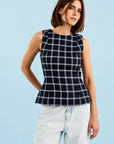 Sleeveless navy plaid Bini Top by Hunter Bell NYC paired with light jeans, styled against a light blue backdrop.