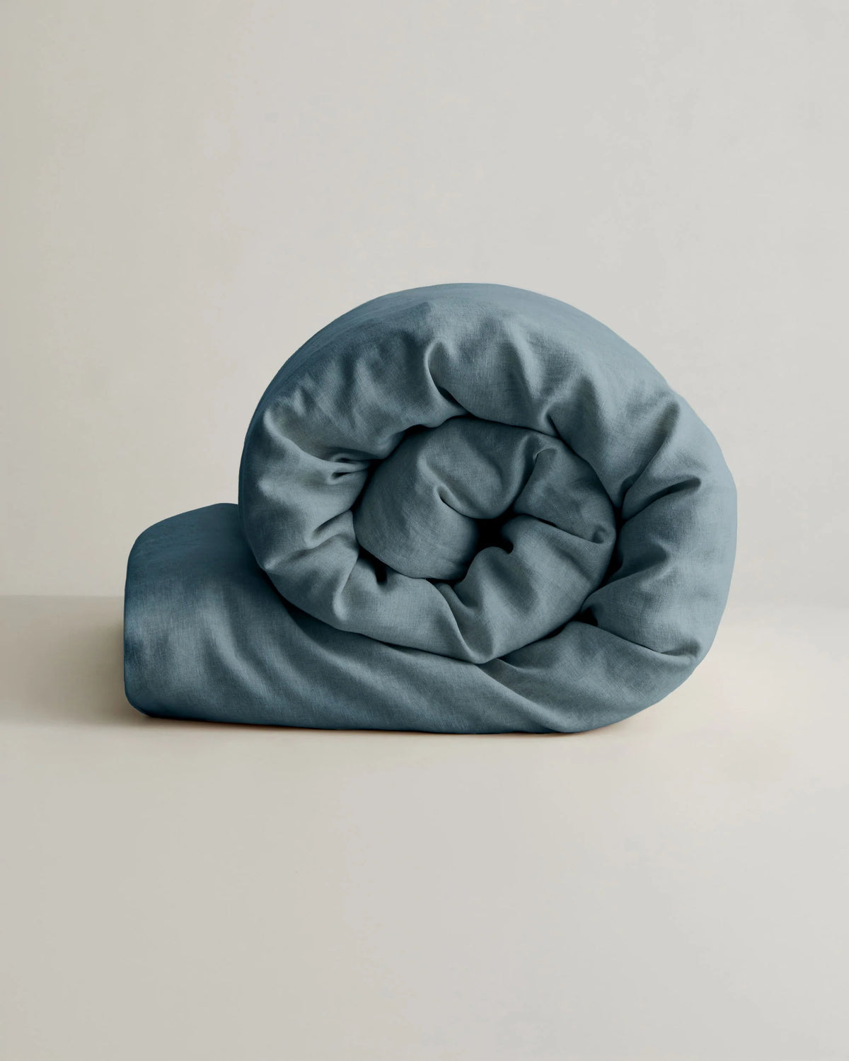 Linen duvet cover in natural tone with blue rolled comforter, by Cultiver Goods USA, crafted from European flax linen.