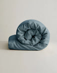 Linen duvet cover in natural tone with blue rolled comforter, by Cultiver Goods USA, crafted from European flax linen.