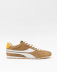 The Essex Sneaker by ONCEPT is an ultra-lightweight shoe in brown Italian calf suede with white accents, a white side stripe, white laces, and a yellow heel tab, shown on a plain white background.