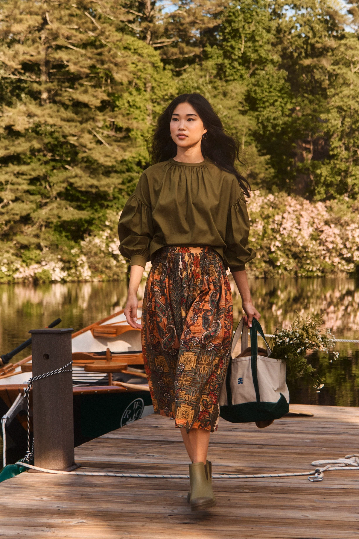 Fallon Skirt by Hunter Bell NYC styled for a lakeside stroll, paired with a casual tote on a dock with trees in view.