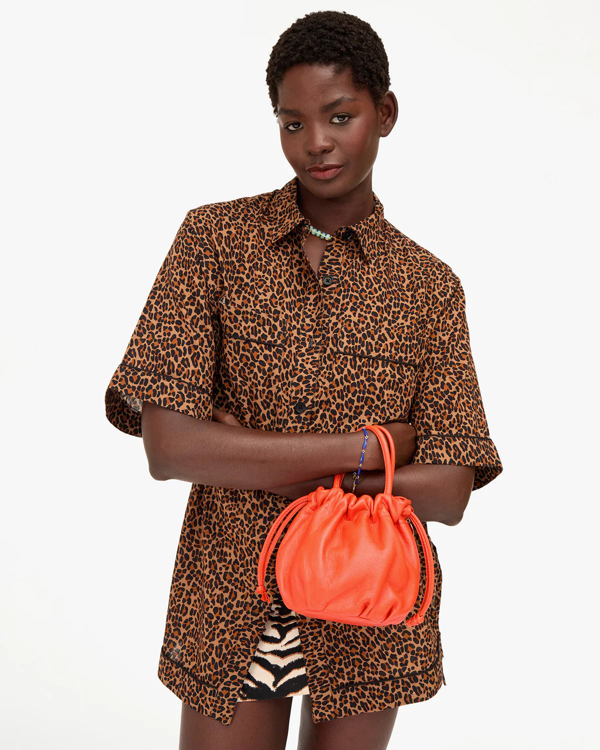 Clare Vivier Emma Top Handle bag held by person in leopard print shirt, white background, modern stylish look.