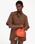 Clare Vivier Emma Top Handle bag held by person in leopard print shirt, white background, modern stylish look.