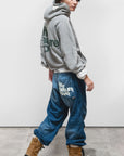 Free City LNL Backprint Fluff Pullover Hoodie in blue, styled with jeans and boots, model glancing over shoulder.