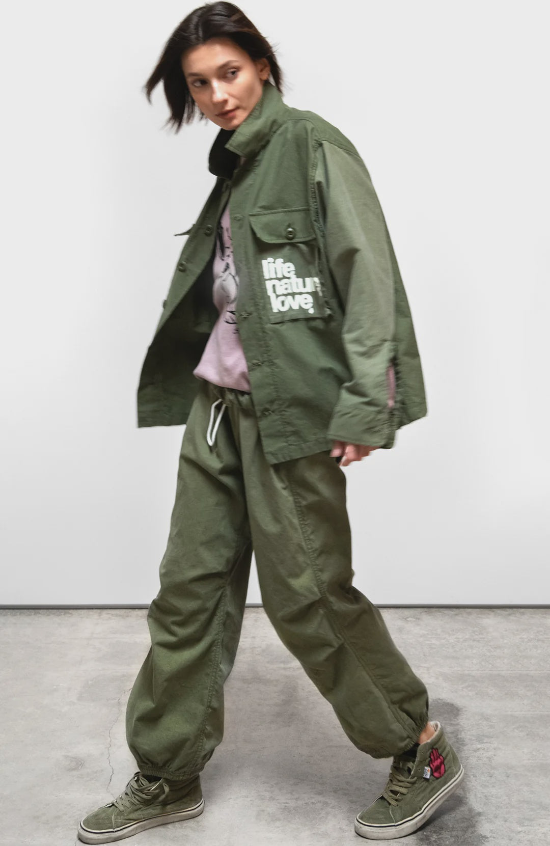 Free City Workshop Biggy Pant in gray styled with a green jacket and pink hoodie indoors at Bungalow Furniture.