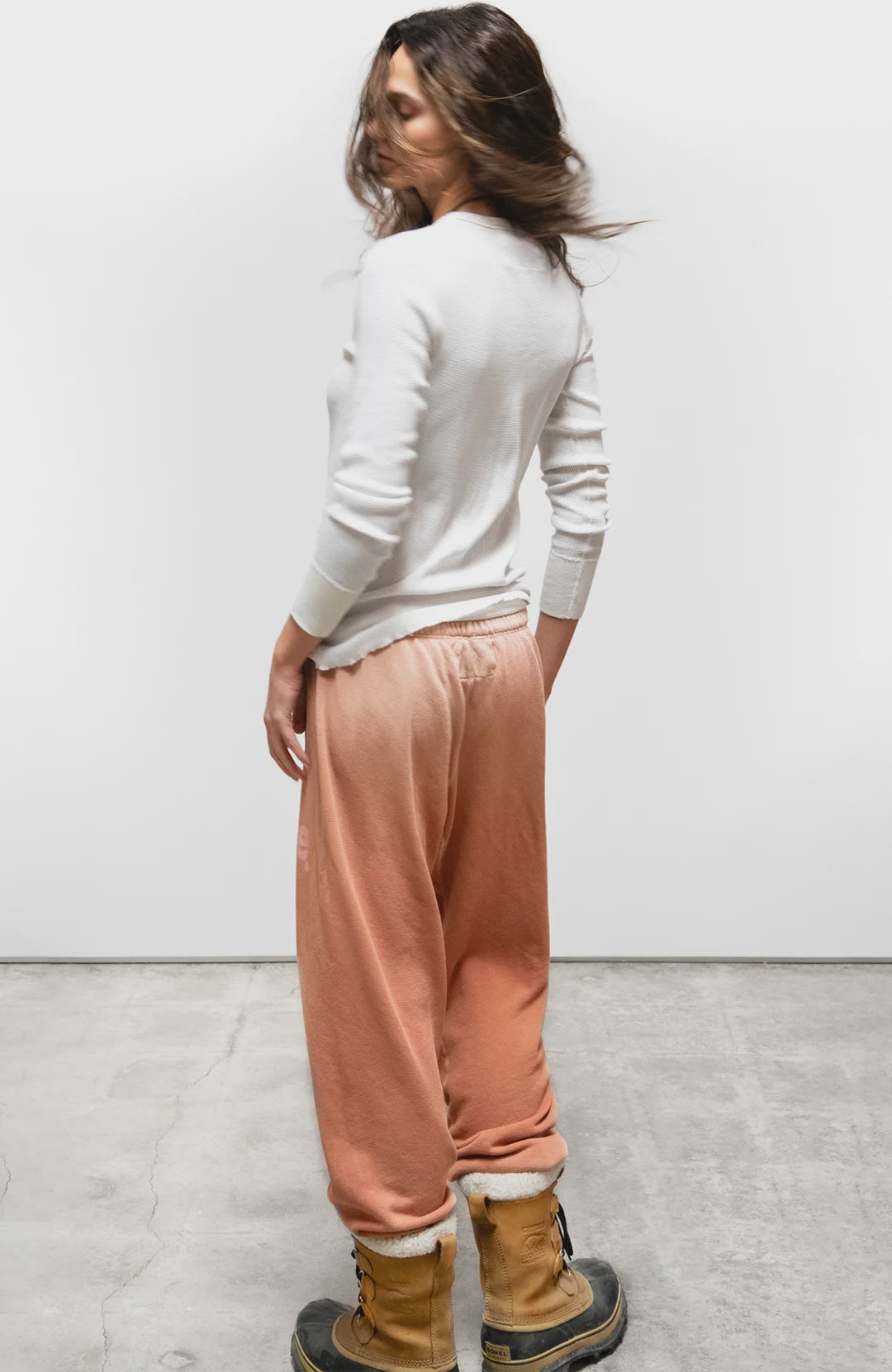 Free City LNL SuperYumm Vintage OG Sweatpant in white with tan boots, casual outdoor setting.