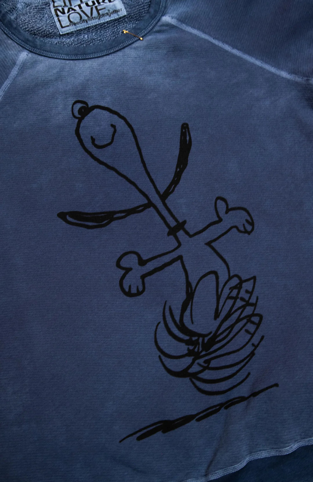 Blue unisex raglan shirt featuring a black line drawing of dancing Snoopy, Free City BasicGoodness Schulz.