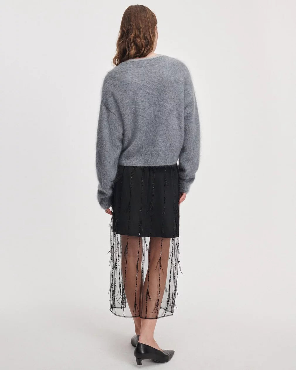Rag &amp; Bone Geena Skirt in black with sheer overlay and a fuzzy gray sweater, worn from behind.