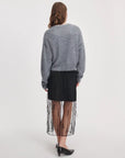 Rag & Bone Geena Skirt in black with sheer overlay and a fuzzy gray sweater, worn from behind.