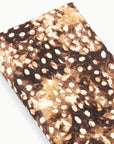 Folded haircalf clutch with brown, black, and tan animal print by Staud Muse, modern accessory for evening use.