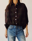 Brown plaid oversized shirt by Hey Gang paired with blue jeans, styled against a minimal light background.