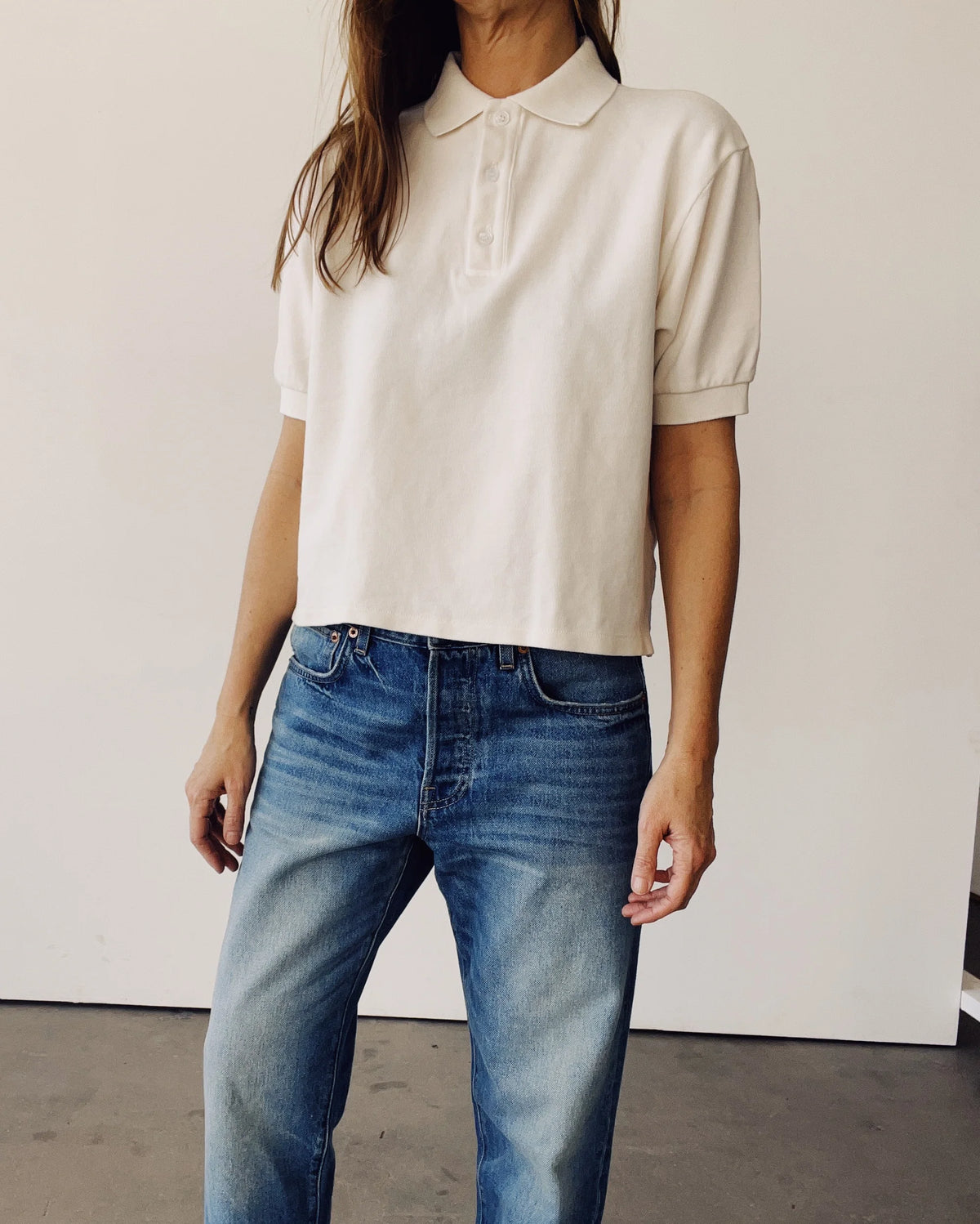 The Boxy Polo in Natural by Hey Gang paired with blue jeans, minimalist style against a simple backdrop.