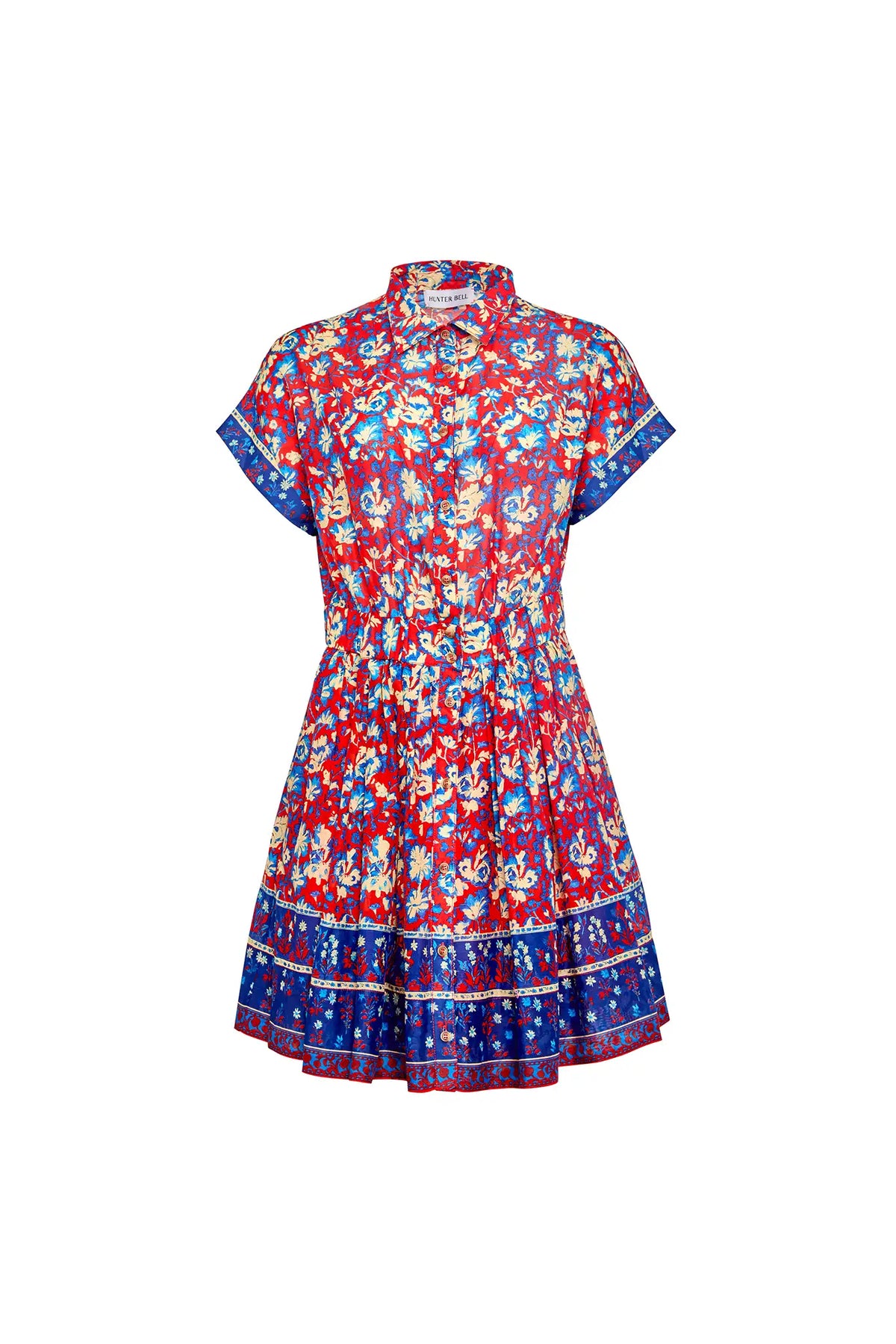 The Howard Dress by Hunter Bell NYC is a short-sleeved, collared button-up featuring a vibrant Tapestry Floral print, flared skirt with blue borders on the hem and sleeves, and an elastic waist for comfort.